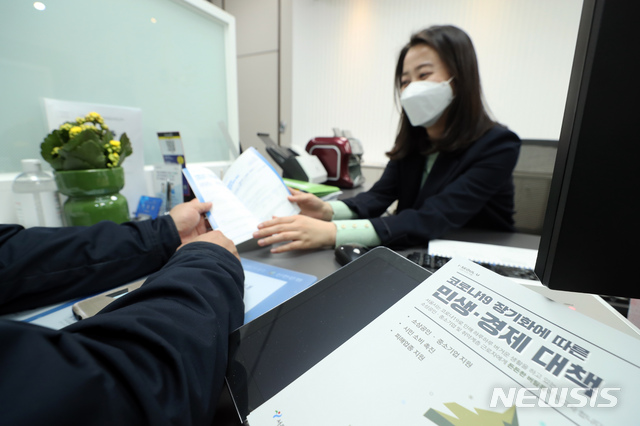 [서울=뉴시스] 이윤청 기자 = 신종 코로나바이러스 감염증(코로나19) 여파로 피해를 입은 중소기업과 소상공인 지원을 위한 '서울시 민생혁신금융 전담창구' 운영을 시작한 6일 서울 중구 신한은행 본점에서 한 소상공인이 관련 상담을 받고 있다. 전담창구에서는 코로나19 피해기업 긴금경영안정자금(8000억원), 서울형 골목상권 119 긴급자금(2000억원), 서울형 이자 비용 절감 대환자금(600억원)에 대한 상담과 실제 지금 지원 등을 실시한다. 2020.04.06. radiohead@newsis.com
