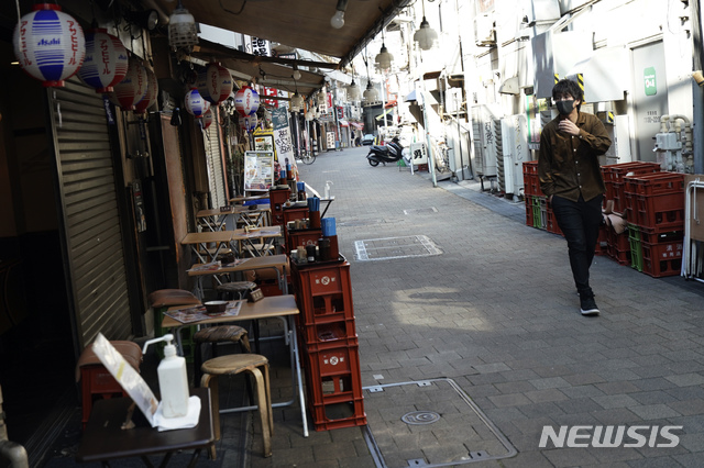 [도쿄=AP/뉴시스]지난 6일 일본 도쿄의 텅 빈 거리에서 한 시민이 문을 닫은 음식점 앞을 지나고 있다. 7일 일본 정부는 신종 코로나바이러스 감염증(코로나19) 확산을 막기 위해 긴급사태 선언을 발령할 전망이다. 2020.04.07.