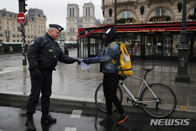 [파리=AP/뉴시스]신종 코로나바이러스 감염증(코로나19)으로 전국이 봉쇄 중인 6일(현지시간) 프랑스 파리에서 한 경관이 행인을 검문하고 있다. 2020.04.07.