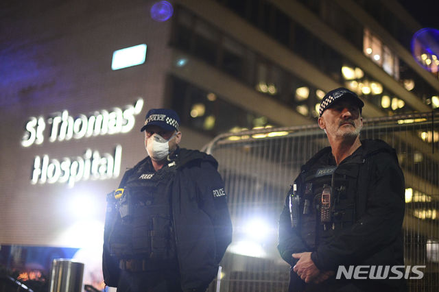 [런던=AP/뉴시스]6일(현지시간) 신종 코로나바이러스 감염증으로 보리스 존슨 영국 총리가 중환자실에 입원한 성 토마스 병원 앞에서 경찰이 근무하고 있다. 총리실은 중환자실에 입원한 존슨 총리가 의식이 있으며 인공호흡기가 필요한 정도는 아니라고 밝혔다. 2020.04.07.