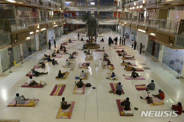 [아마다바드=AP/뉴시스]신종 코로나바이러스 감염증(코로나19) 확산을 막기 위해 인도 아마다바드의 한 쇼핑몰에 마련된 임시 주거지에서 7일(현지시간) 타주 이주 노동자들이 노숙자들과 함께 휴식을 취하고 있다. 2020.04.08.