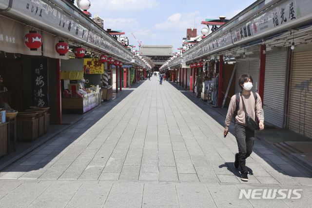 [도쿄=AP/뉴시스]지난 8일 일본 도쿄 아사쿠사의 상점가 '나카미세' 거리가 텅 빈 가운데 한 시민이 마스크를 쓴 채 걸어가고 있다. 지난 7일 도쿄 등 7개 지역에 신종 코로나비아러스 감염증(코로나19) 확산을 막기 위해 긴급사태 선언이 발령됐다. 2020.04.09.