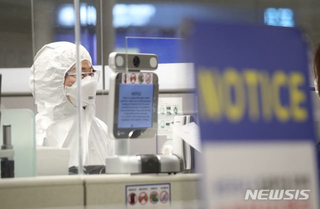 [인천공항=뉴시스] 고범준 기자 = 인천공항 출입국 외국인청 입국심사관이 8일 오후 인천국제공항 제2터미널 유증상자전용 입국심사대에서 방진복을 입은 채 업무를 준비하고 있다. 2020.04.08.    photo@newsis.com