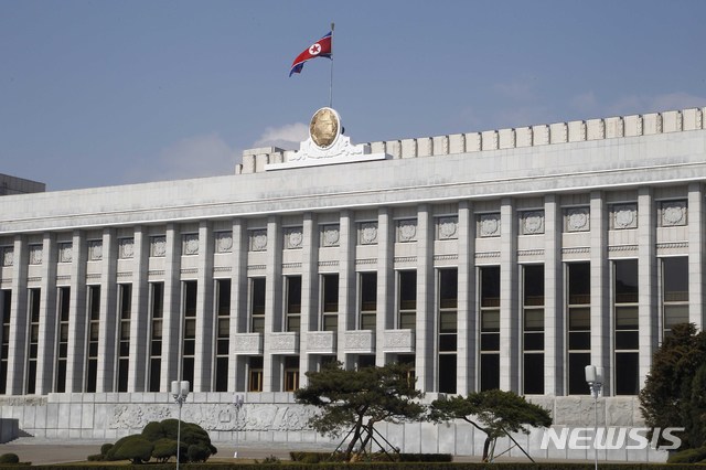 [평양=AP/뉴시스]9일 평양 시민들이 최고인민회의 상임위 청사 꼭대기에 북한 인공기가 펄럭이고 있다. 북한은 10일 제14기 제3차 최고인민회의를 개최한다. 대한민국의 정기국회에 해당하는 최고인민회의는 북한의 최고 주권 기관으로 국가정책의 기본원칙을 수립하고 주요 국가기구 인사, 예산안 승인 등의 기능을 수행한다. 2020.04.09. 