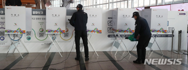 [서울=뉴시스]김병문 기자 = 제21대 국회의원선거 사전투표를 하루 앞둔 9일 오후 서울 용산구 서울역 대합실에 설치된 남영동 사전투표소에서 방역 관계자들이 기표소를 방역 소독 작업하고 있다. 2020.04.09.&nbsp; photo@newsis.com