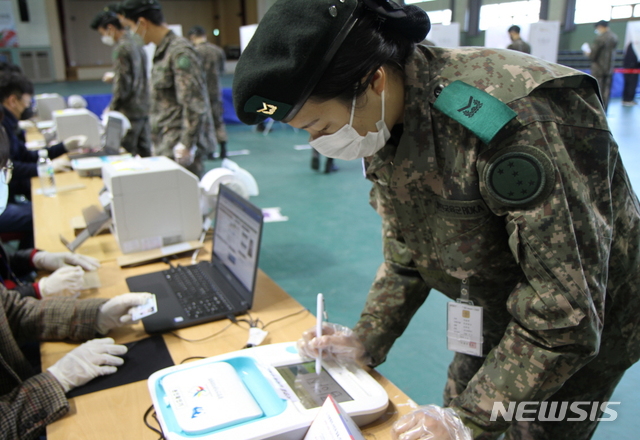 【화천=뉴시스】한윤식 기자 = 4·15 총선 사전투표 첫날인 10일 오전 강원 화천군실내체육관에 마련된 사전투표소서 군장병이 투표에 앞서 본인 신분 확인을 하고 있다. 2020.04.10.ysh@newsis.com