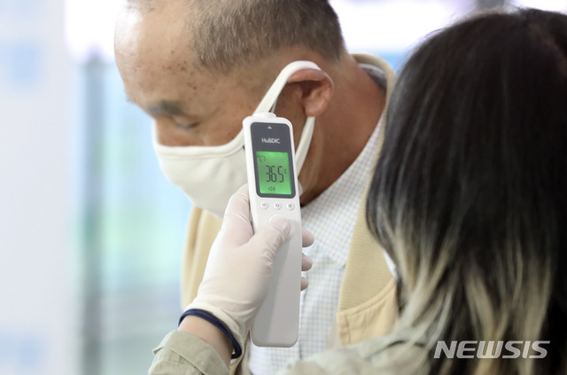 [서울=뉴시스]최진석 기자 = 제21대 국회의원 선거 사전투표 시작일인 10일 오전 서울역에 차려진 남영동 사전투표소에서 한 유권자가 투표에 앞서 발열체크를 받고 있다. 2020.04.10.myjs@newsis.com