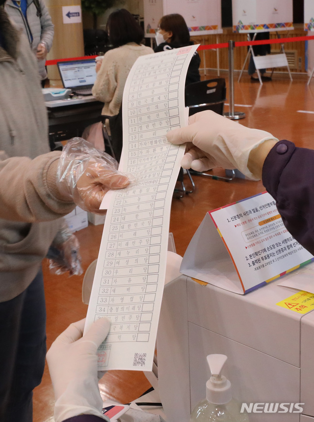 [고양=뉴시스] 전진환 기자 = 제21대 국회의원선거 사전투표일인 10일 오전 경기도 고양시 덕양구청에 마련된 사전투표소에서 한 유권자가 투표용지를 받고 있다. 2020.04.10.&nbsp; amin2@newsis.com