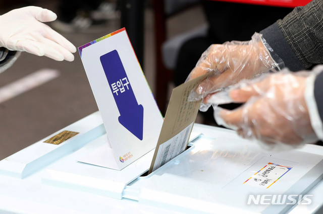 [제주=뉴시스]우장호 기자 = 제21대 국회의원 선거 사전투표 첫날인 10일 오전 제주도의회 의원회관 1층에 마련된 연동투표소에서 한 유권자가 신종 코로나바이러스 감염증(코로나19) 예방을 위해 나눠준 비닐장갑을 끼고 투표를 하고 있다. 2020.04.10. woo1223@newsis.com