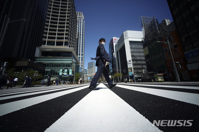 [도쿄=AP/뉴시스]지난 10일 일본 도쿄의 한 거리에서 신종 코로나바이러스 감염증(코로나19) 감염을 막기 위해 마스크를 쓴 시민이 횡단보도를 건너고 있다. 0220.04.13.