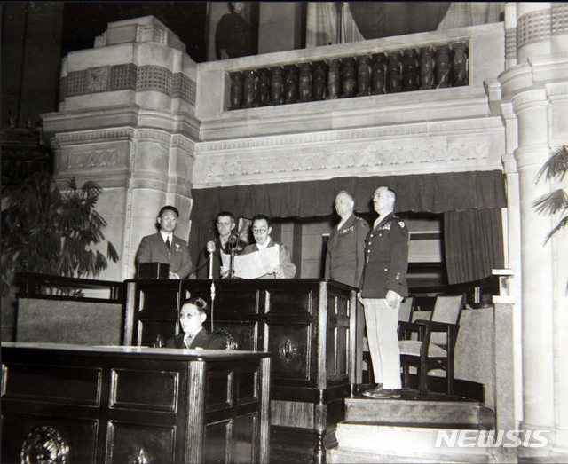 [서울=뉴시스] 1946년 12월 12일 정오, 중앙청 제1 회의실에서 개최된 남조선과도입법의원 개원식에서 김규식(金奎植) 의장이 개회사를 낭독하고 있다. 오른쪽부터 미군정장관 대리 헬믹 대장, 미소공동위원회 미국 측 수석대표 브라운 소장, 김규식 의장, 주한미군사령관 하지 중장. 단상 앞쪽은 전규홍(全奎弘) 과도입법의원 사무총장. (사진=미국 국립문서기록청) 2020.04.12. photo@newsis.com (* 위 사진은 재배포, 재판매, DB 및 활용을 금지합니다)