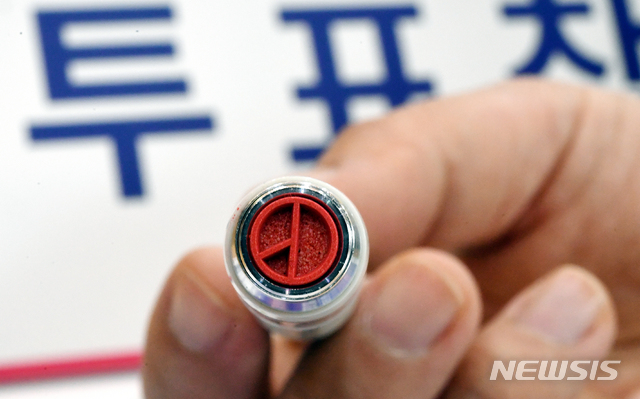 [서울=뉴시스] 전진환 기자 = 제21대 국회의원 선거를 하루 앞둔 14일 오후 청운효자동 제1투표소가 설치된 서울 종로구 청운초등학교 강당에서 선거사무원이 기표도장을 들어보이고 있다. 2020.04.14. photo@newsis.com