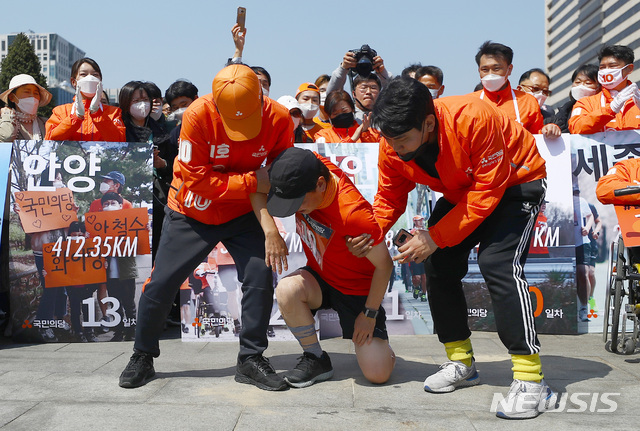 [서울=뉴시스]전신 기자 = 지난 1일부터 국토종주에 나선 안철수 국민의당 대표가 14일 서울 종로구 광화문광장에 도착해 절을 한 후 당 관계자들의 부축을 받으며 일어서고 있다. 2020.04.14.&nbsp; photo1006@newsis.com
