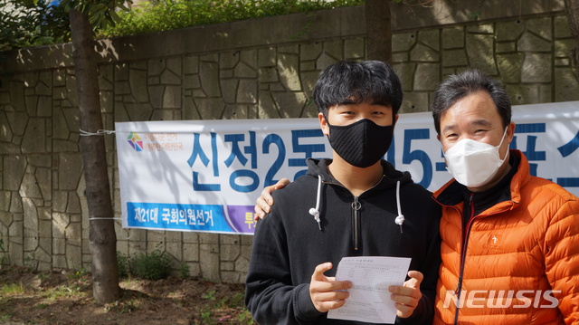 [울산=뉴시스] 구미현 기자 = 제21대 국회의원 선거일인 15일 울산 남구 신정2동 문수로아이파크 1단지 내 제5투표소에서 학성고등학교 3학년 박진원 학생이 고3 유권자들에게 투표를 당부하며 아버지와 함께 기념촬영을 하고 있다. 2020.04.15. gorgeouskoo@newsis.com