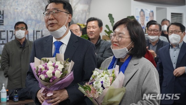 윤영찬 당선인과 부인 김미경씨가 선거캠프에서 축하꽃다발을 받고 있다.