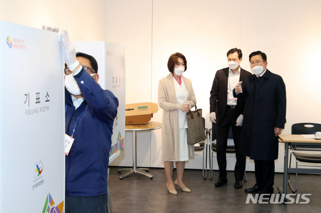 [서울=뉴시스] 고승민 기자 = 제21대 국회의원 선거에 출마하는 황교안 미래통합당 종로구 후보가 선거일인 15일 서울 종로구 혜화동 제3투표소에서 기표를 하려다 기표소를 나와 투표관리관에게 비밀보장 등의 조치에 대해 이야기를 하고 있다. 그러자 관계자가 기표소에 가림막을 설치하고 있다. 2020.04.15. kkssmm99@newsis.com