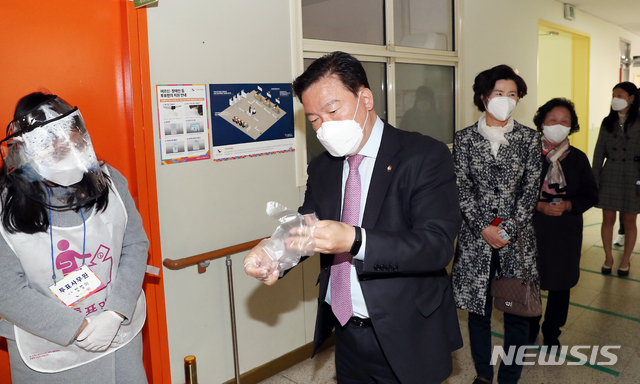 [인천=뉴시스] 이종철 기자 = 제21대 국회의원선거 투표일인 지난 15일 오전 인천시 연수구 송도1동 제4투표소 신송초등학교에서 민경욱 미래통합당 인천 연수구을 후보가 신종 코로나감염증(코로나19) 예방을 위해 투표를 하기 전 비닐장갑을 끼고 있다. 2020.04.15. jc4321@newsis.com