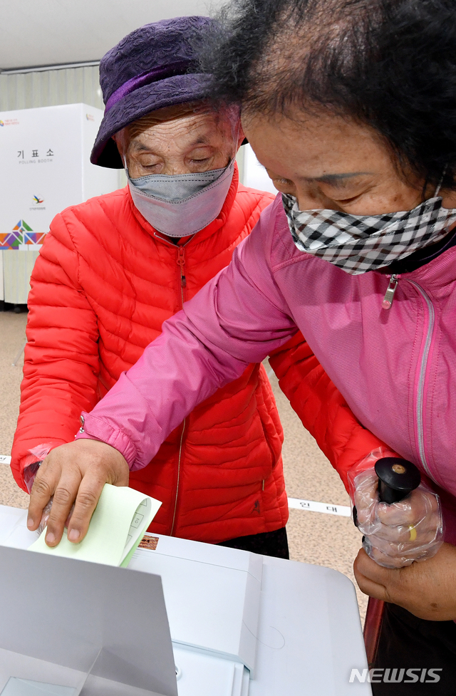 [광주=뉴시스] 신대희 기자 = 제21대 국회의원 선거 당일인 15일 오전 광주 북구 문흥동 박명순(116·왼쪽)씨가 큰 며느리의 손을 잡고 문흥1동 제1투표소에서 투표를 하고 있다. 2020.04.15. sdhdream@newsis.com