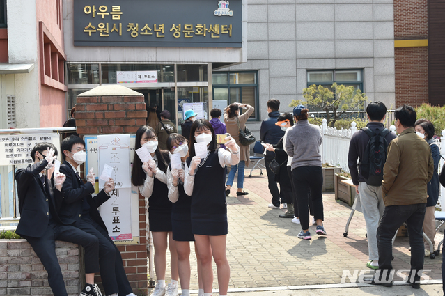 [수원=뉴시스] 김종택 기자 = 제21대 국회의원선거 투표일인 15일 경기 수원시 장안구 조원동 수원시 청소년 성문화센터에 마련된 투표소에서 첫 투표를 마친 조원고등학교 3학년인 만 18세 학생유권자들이 투표 확인증을 들고 인증샷을 남기고 있다. 2020.04.15.semail3778@naver.com