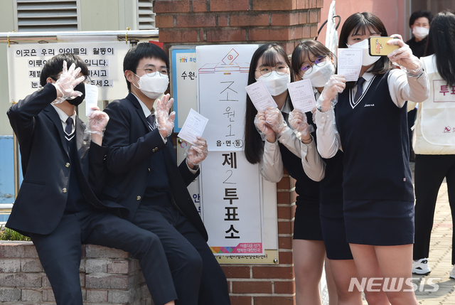 [수원=뉴시스] 김종택 기자 = 제21대 국회의원선거 투표일인 15일 경기 수원시 장안구 조원동 수원시 청소년 성문화센터에 마련된 투표소에서 첫 투표를 마친 조원고등학교 3학년인 만 18세 학생유권자들이 투표 확인증을 들고 인증샷을 남기고 있다. 2020.04.15.semail3778@naver.com