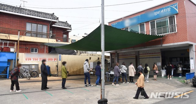 [부산=뉴시스] 하경민 기자 = 제21대 국회의원 선거일인 15일 오전 부산 수영구 광안제1동 제4투표소가 마련된 자동차정비세차장에서 유권자들이 투표를 하기 위해 길게 줄을 서고 있다. 2020.04.15. yulnetphoto@newsis.com