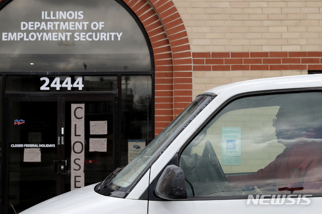 A man looks at the closed sign in front of Illinois Department of Employment Security in Chicago, Wednesday, April 15, 2020. With half-a-million people bounced out of jobs in the past month because of the COVID-19 pandemic, Illinois' unemployment safety net has been stretched to the limit. (AP Photo/Nam Y. Huh)