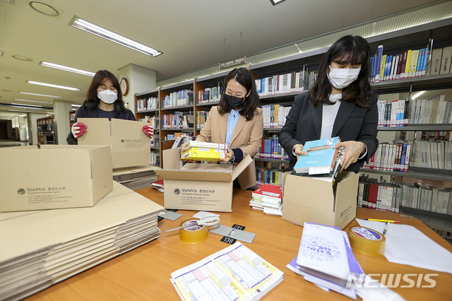 영남대 도서관 직원들이 학생들에게 배송할 책을 포장하고 있다 