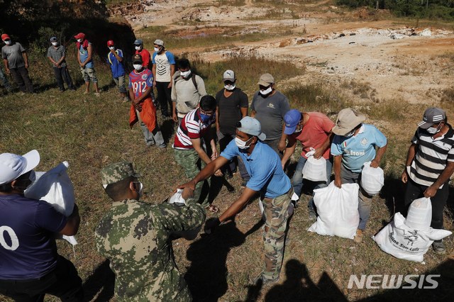 [엠보스카다=AP/뉴시스] 4월 파라과이 엠보스카다 지역의 광부들이 해군 선원이 나눠주는 곡물을 수령하고 있다. 파라과이 정부는 신종 코로나바이러스 감염증(코로나19) 여파로 경제적 위기를 겪는 저소득층 가정이 식료품을 구입할 수 있도록 월 80만원의 기본소득을 지급하고 있다. 2020.8.28.