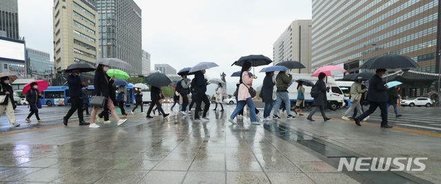 [서울=뉴시스] 이윤청 기자 = 지난달 17일 서울 종로구 광화문광장 인근에서 시민들이 우산을 쓰고 걷고 있다. 2020.04.17. radiohead@newsis.com