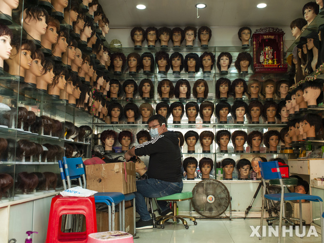 [우한=신화/뉴시스]16일(현지시간) 중국 후베이성 우한의 한 가발 가게에서 마스크를 쓴 한 남성이 일하고 있다. 중국 내 신종 코로나바이러스 감염병(코로나19)의 확산이 누그러들면서 우한에서는 생활이 점차 일상으로 돌아오고 있다. 2020.04.17.