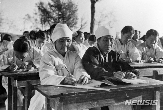 [서울=뉴시스] 1946년 여름 12세 이상 50세 미만의 남녀 문맹자를 대상으로 개설된 ‘성인학교’에서 한글을 배우는 주민들의 표정이 진지하다. (사진=미디어한국학 제공) 2020.04.19. photo@newsis.com
