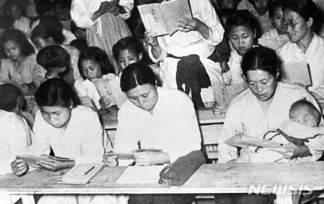 [서울=뉴시스] 1946년 여름 12세 이상 50세 미만의 남녀 문맹자를 대상으로 개설된 ‘성인학교’에서 여성들이 한글을 배우고 있다. 아이를 안고 공부하는 여성의 모습이 이채롭다. (사진=미디어한국학 제공) 2020.04.19. photo@newsis.com