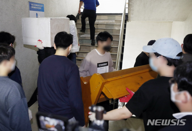 [과천=뉴시스] 최동준 기자 = 신천지 과천총회본부 관계자들이 지난 20일 경기 과천시 한 상가 빌딩에 불법 용도 변경해 사용 중이던 예배당 의자와 집기 등을 옮기고 있다. 2020.04.20. photocdj@newsis.com 이 사진은 기사 내용과 직접적인 관련 없음