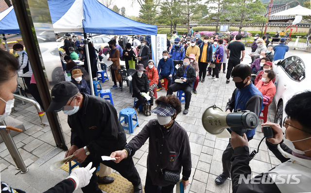 [수원=뉴시스] 김종택 기자 = 경기도 재난기본소득 방문 신청일인 20일 오전 경기 수원시 팔달구 한 행정복지센터에서 신청자들이 번호표를 담당 공무원에게 보여주고 있다.경기도는 31개 시군 전역 545개 읍면동 행정복지센터와 216개 농협지점, 725개 지역농축협 지점에서 경기도 재난기본소득 선불카드 신청 접수를 실시한다고 밝혔다. 2020.04.20.semail3778@naver.com