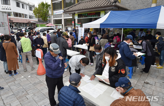 [수원=뉴시스] 김종택 기자 = 경기도 재난기본소득 방문 신청일인 20일 오전 경기 수원시 팔달구 한 행정복지센터에서 신청자들이 신청서를 작성하고 있다.경기도는 31개 시군 전역 545개 읍면동 행정복지센터와 216개 농협지점, 725개 지역농축협 지점에서 경기도 재난기본소득 선불카드 신청 접수를 실시한다고 밝혔다. 2020.04.20.semail3778@naver.com