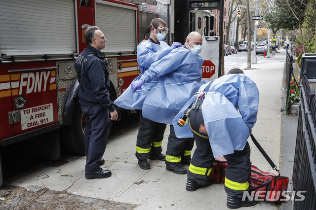 [ 뉴욕= AP/뉴시스] 올 4월 17일 뉴욕시 소방구조대원들이 브루클린의 코블 힐 요양센터에 진입하기 전에 방호복을 착용하고 있다. 이곳에서는 코로나19 감염 증상을 보이는 사람이 거의 절반인데도 검사가 이뤄지지 않고 보호장구도 공급되지 않아서 수용인들이 대형 쓰레기 봉투를 방호복으로 입고 있었다.&nbsp; 