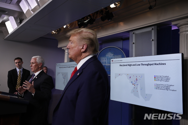 [워싱턴=AP/뉴시스] 20일(현지시간) 미국 워싱턴 백악관에서 열린 신종 코로나바이러스 감염증(코로나19) 태스크포스 브리핑에서 도널드 트럼프 미국 대통령이 마이크 펜스 부통령의 발언을 듣고 있다. 이날 펜스 부통령은 메릴랜드 주의 코로나19 검사시설을 지도로 표시한 슬라이드를 준비해 나와 한국에서 진단키트를 확보한 래리 호건 메릴랜드 주지사를 질책했다. 2020.4.21.