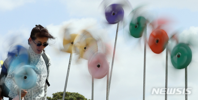 [세종=뉴시스]강종민 기자 = 서울을 비롯한 중부와 전북, 경북 지방에 강풍주의보가 발효된 전날 세종시 어진동 세종호수공원에서 시민들이 쉬지않고 돌아가는 바람개비 사이로 산책하고 있다. 2020.04.21. ppkjm@newsis.com