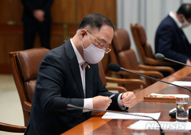 [서울=뉴시스]박영태 기자 = 홍남기 경제부총리 겸 기획재정부 장관이 22일 청와대 본관에서 열린 제5차 비상경제회의에 참석해 자료를 검토하고 있다. 2020.04.22&nbsp; since1999@newsis.com