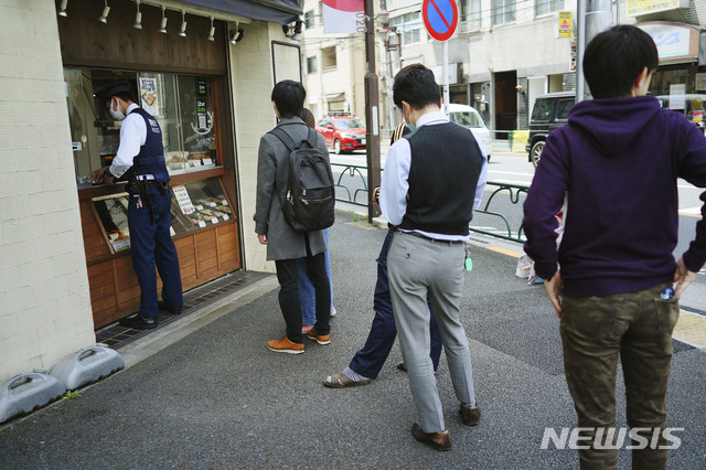 [도쿄=AP/뉴시스]22일(현지시간) 일본 도쿄의 한 식당 앞에 신종 코로나바이러스 감염증(코로나19)의 확산을 막기 위해 마스크를 쓴 사람들이 점심을 사기 위해 줄서 있다. 2020.04.22.