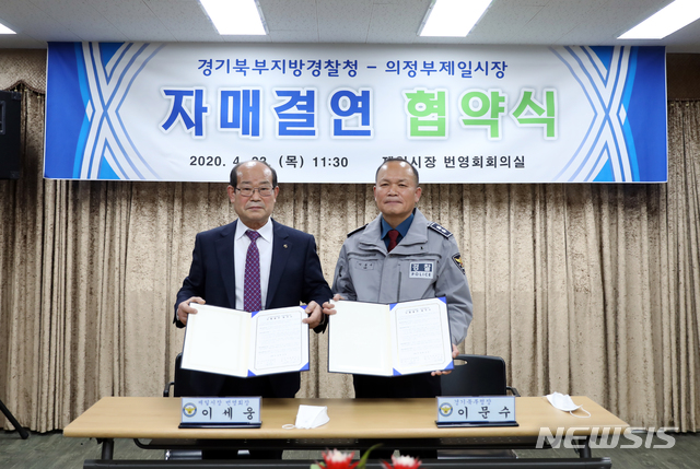 이세웅 의정부 제일시장 번영회장(사진 좌측)과 이문수 경기북부지방경찰청장이 23일 전통시장 이용촉진을 위한 자매결연을 체결한 뒤 기념촬영을 하고 있다.&nbsp; (사진=경기북부지방경찰청 제공)