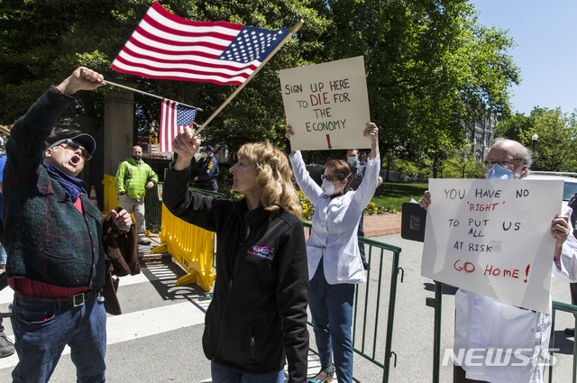 [윈체스터=AP/뉴시스]22일(현지시간) 조지아 윈체스터에서 국가 재개방(경제활동 재개)에 반대하는 피켓을 든 시위대와 재개방을 요구하는 시위대가 한 자리에 선 모습. 2020.04.23.