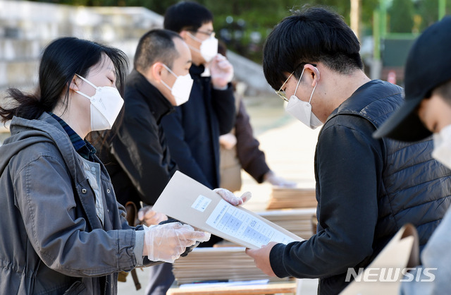 [대구=뉴시스] 이무열 기자 = 신종 코로나바이러스 감염증(코로나19) 우려로 5차례 연기됐던 올해 첫 수능 모의평가가 시행된 24일 오전 대구 수성구 황금동 경북고등학교 운동장에서 교사들이 워킹 스루 방법으로 학생간 대면을 최소화 하며 전국연합학력평가 시험지를 학생들에게 배부하고 있다. 2020.04.24.lmy@newsis.com