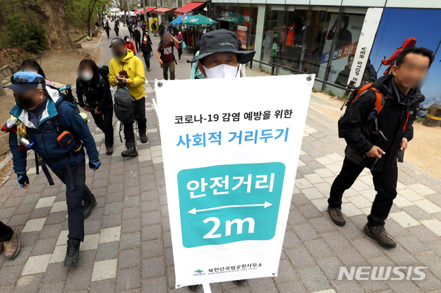[서울=뉴시스] 이윤청 기자 = 국립공원공단 북한산사무소 직원들과 산악회 회원들이 25일 서울 은평구 북한산성탐방지원센터 인근 등산로에서 사회적 거리두기 실천을 홍보하고 있다. 이번에 환경부와 국립공원공단이 마련한 안전수칙에 따라 탐방객들은 ▲다른 사람과 2m 이상 거리두기 ▲국립공원 정상·쉼터 등에서 떨어져 앉고 오래 머물지 않기 ▲탐방로 우측 한줄 통행 ▲마스크 착용 및 손 씻기 등의 수칙을 지켜야 한다. 2020.04.25. radiohead@newsis.com