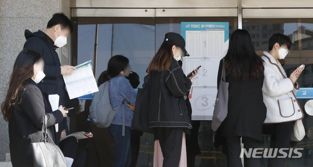 [서울=뉴시스] 서울 시내의 한 토익 시험장 앞에서 마스크를 착용한 응시자들이 대기하고 있다. (사진=뉴시스 DB). photo@newsis.com