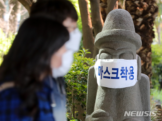 [제주=뉴시스]우장호 기자 = 정부가 고강도 사회적 거리두기를 제한적으로 완화한 가운데 28일 오전 제주국제공항에 서 있는 돌하르방이 신종 코로나바이러스 감염증(코로나19) 예방 마스크를 쓰고 있다. 제주도는 오는 30일부터 시작되는 황금연휴 기간 동안 '코로나19' 주의 환기 차원에서 도내 관광지 40여기의 돌하르방에 마스크를 씌우기로 했다. 2020.04.28.&nbsp; woo1223@newsis.com