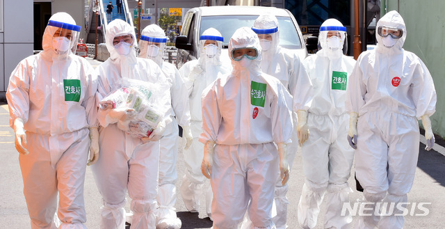 [대구=뉴시스] 이무열 기자 = 국내 첫 신종 코로나바이러스 감염증(코로나19) 확진환자가 발생한지 100일째인 28일 오후 코로나19 지역거점병원인 대구 중구 계명대학교 대구동산병원에서 근무 교대를 위해 방호복을 착용한 의료진이 병동으로 들어가고 있다. 2020.04.28.&nbsp; lmy@newsis.com