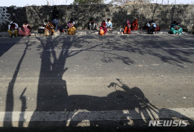 [뭄바이=AP/뉴시스]28일(현지시간) 인도 뭄바이에서 경찰이 신종 코로나바이러스 감염증(코로나19) 확산 예방을 위해 이주민들의 이동을 막아 이주민들이 시 경계에 앉아 있다. 인도 정부는 지난주 수백만 명의 빈민과 일용직 노동자들을 돕기 위해 상점, 제조업, 농업 등의 조업 재개를 허용하면서 코로나19 폐쇄를 완화했다. 그러나 전국적인 폐쇄로 인한 경제적 손실은 계속 증가하는 것으로 나타났다. 2020.04.29.