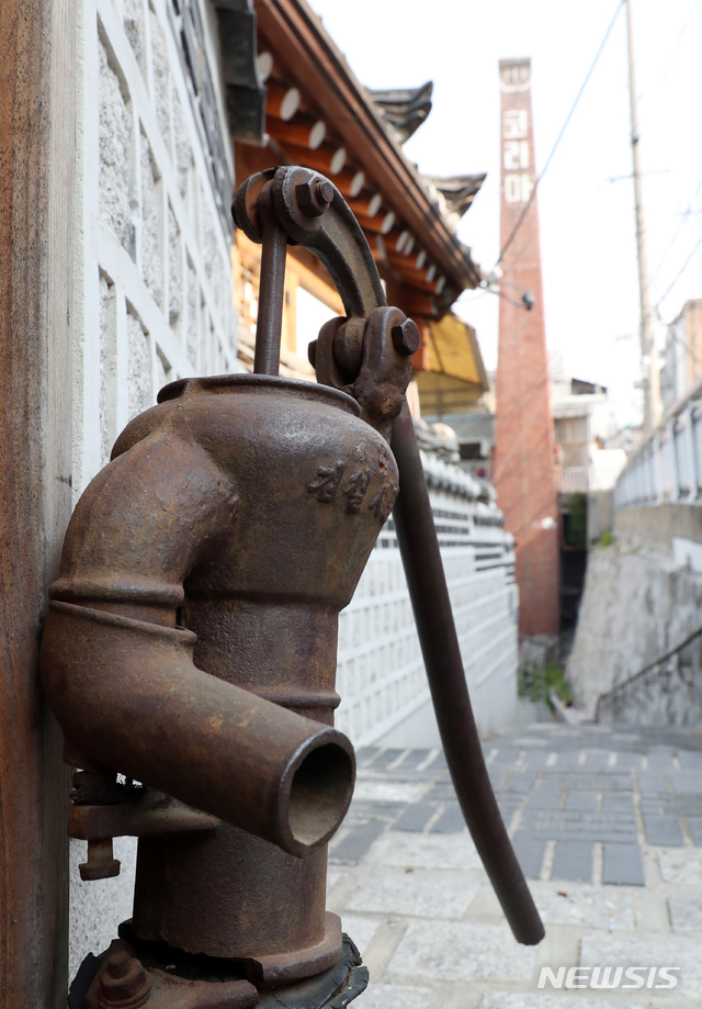 [서울=뉴시스]박영태 = 29일 서울 삼청동 한옥 골목에 작두펌프가 인테리어 소품으로 설치되어 있고 뒤에는 코리아 목욕탕의 오래된 굴뚝이 보이고 있다. 2020.05.09. since1999@newsis.com