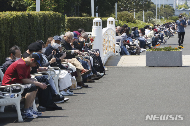 [도쿄=AP/뉴시스]29일 일본 도쿄 인근 요코하마의 한 공원 벤치에 휴일을 맞은 시민들이 사회적 거리 두기를 준수하지 않은 채 빽빽이 앉아 있다. 일본은 29일 쇼와 천황의 생일인 '쇼와의 날'을 휴일로 지내고 있다. 일본 중의원은 전 국민에게 1인당 10만 엔(약 110만 원)의 현금을 지급하는 등의 내용을 담은 추경 예산안을 만장일치로 가결했다. 2020.04.29. 